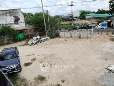 Vacant land plot with construction materials and parked vehicle, ideal for development.