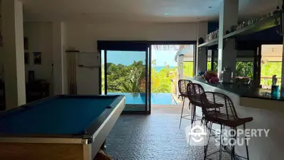 Luxurious open-plan living area with pool table and ocean view, perfect for entertainment and relaxation.