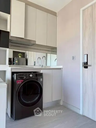 Modern kitchen with sleek cabinetry and integrated washing machine in a compact layout.