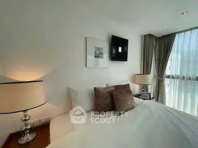 Elegant bedroom with modern decor and large window offering natural light