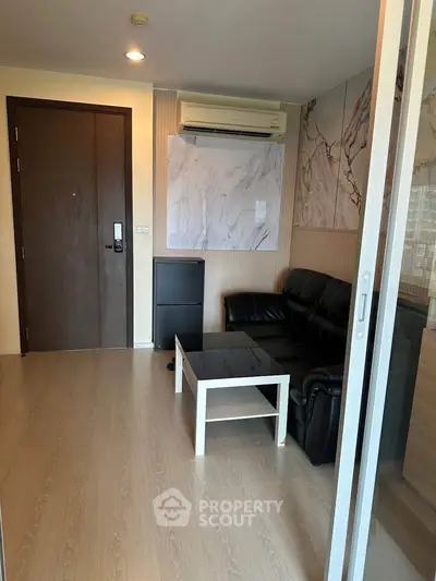 Modern living room with sleek design, featuring leather sofa and air conditioning, perfect for urban living.