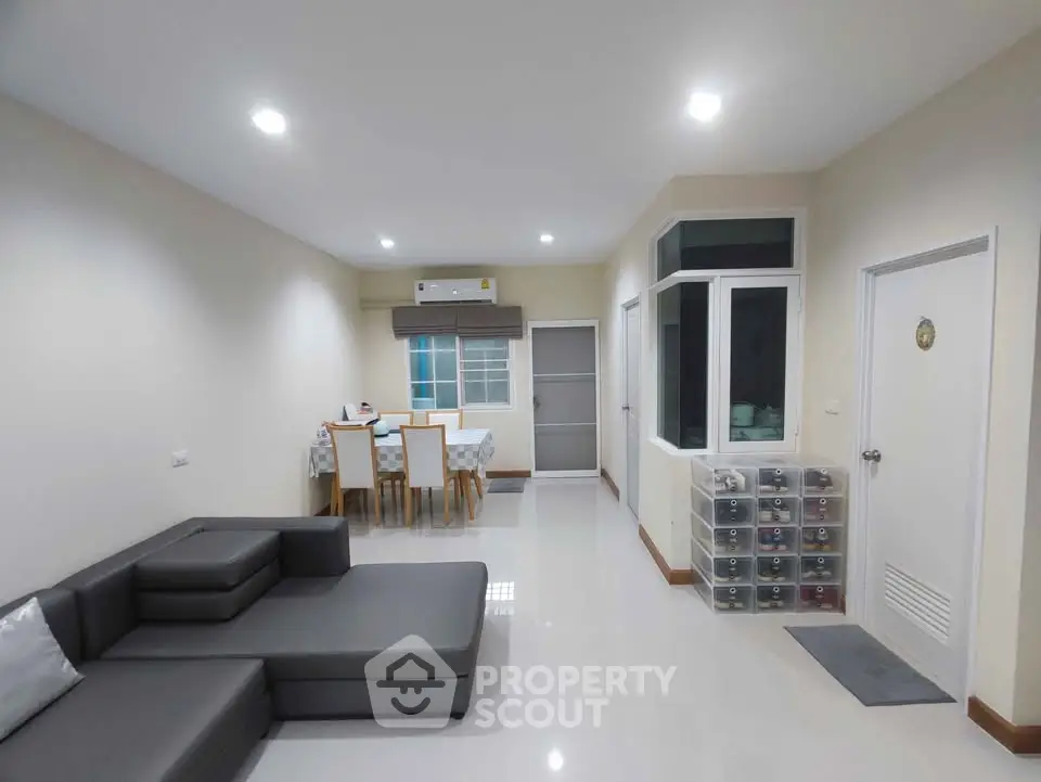Spacious modern living room with sleek furniture and dining area, perfect for family gatherings.