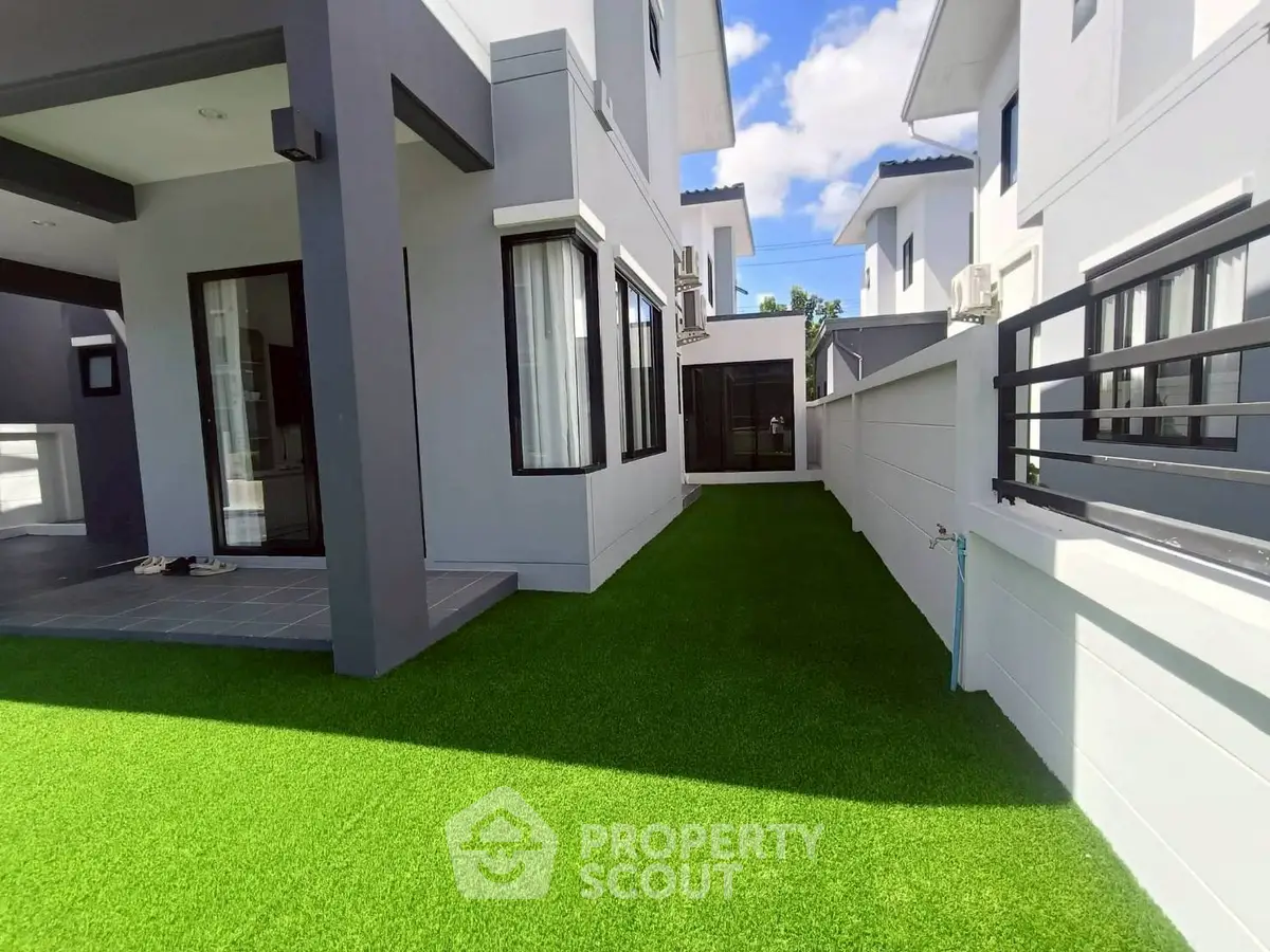 Modern townhouse with lush green lawn and sleek exterior design