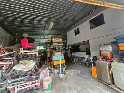 Spacious storage area with metal roof and various items, ideal for warehouse use.