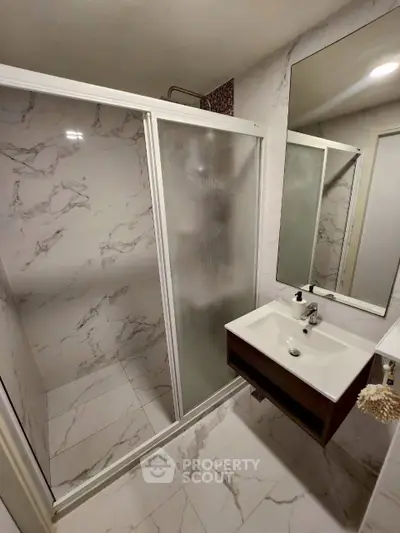 Modern bathroom with marble tiles and sleek shower enclosure