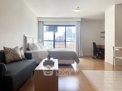 Spacious studio apartment with city view, featuring modern furnishings and natural light.