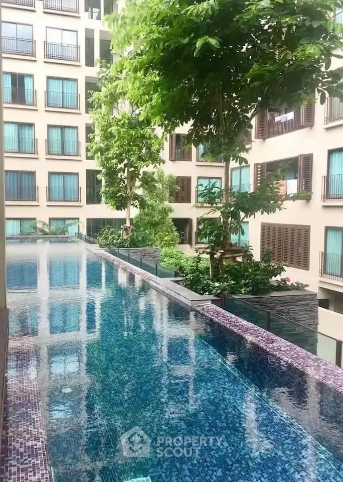 Luxurious apartment complex with stunning pool and lush greenery