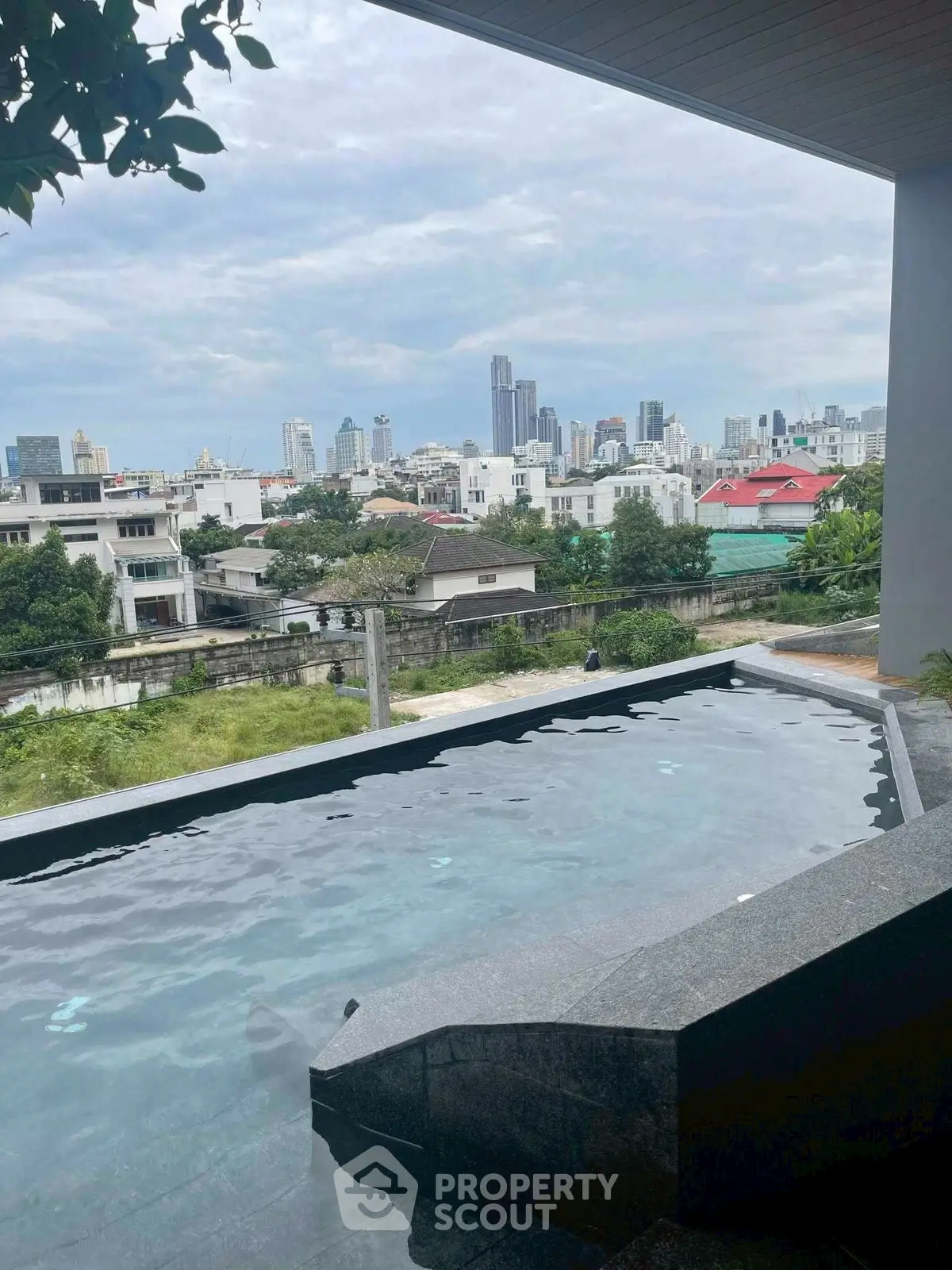 Luxurious rooftop infinity pool with stunning city skyline view, perfect for urban living enthusiasts.