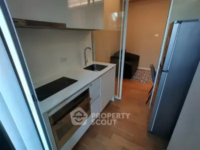 Modern compact kitchen with sleek appliances and cozy living area, perfect for urban living.