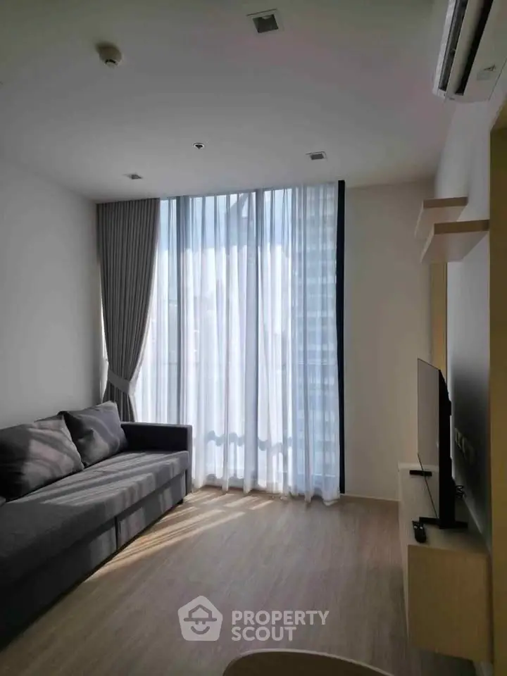 Modern living room with large window and stylish sofa in a bright apartment.