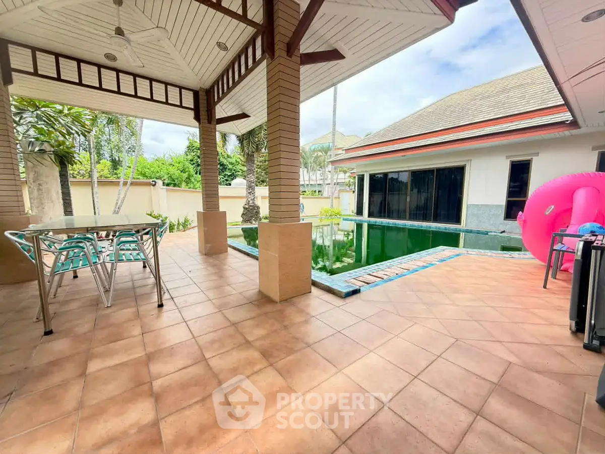 Spacious outdoor patio with pool and modern furniture in a luxurious villa setting.
