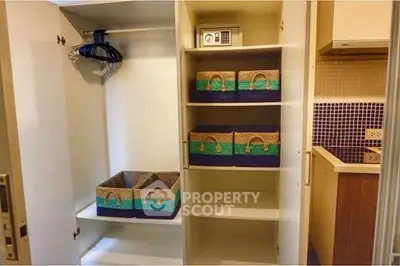Spacious storage closet with organized shelves and kitchen view