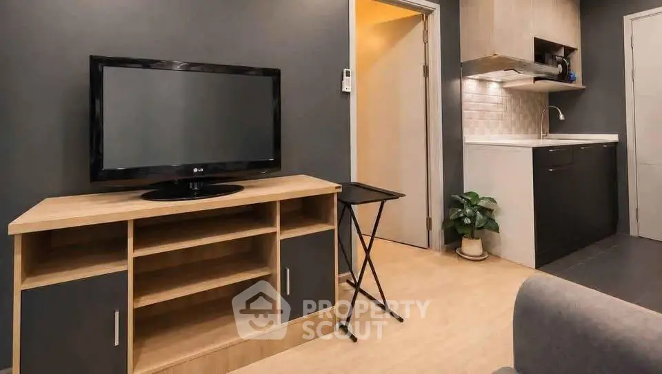 Modern living room with sleek TV stand and compact kitchen area, perfect for urban living.