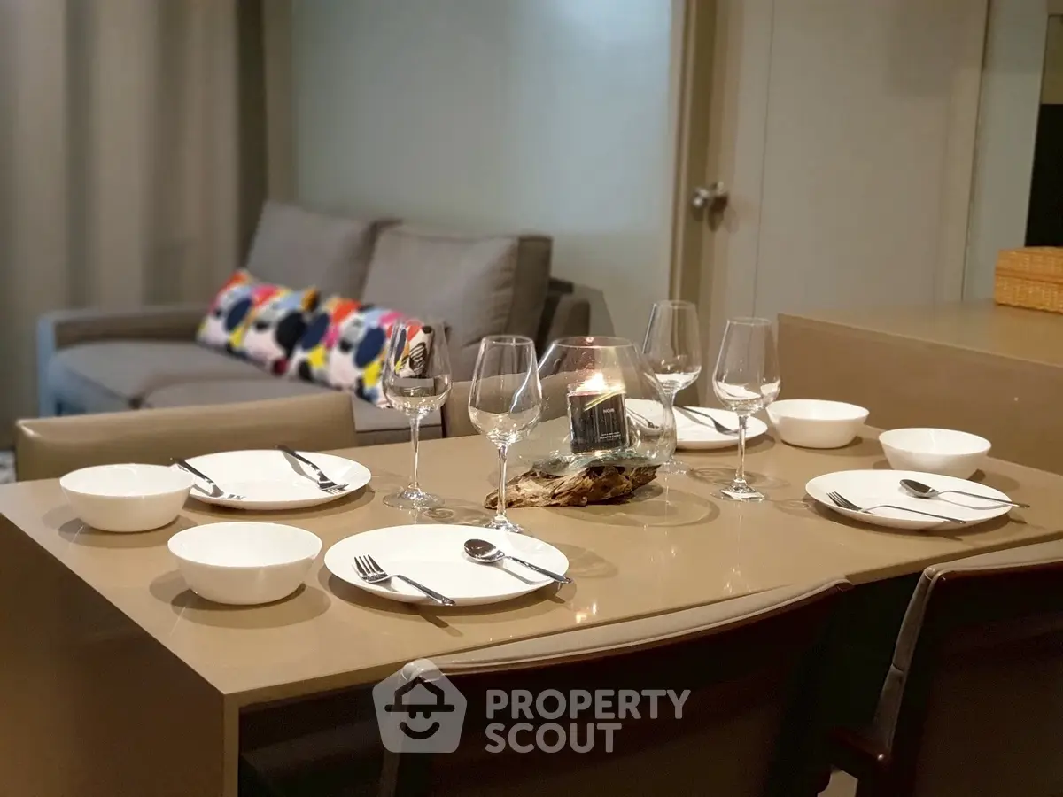 Modern dining area with elegant table setting and cozy living room in background.
