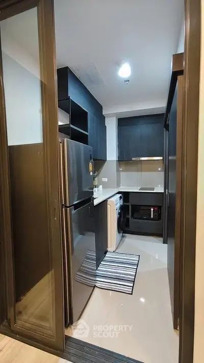 Modern compact kitchen with sleek appliances and stylish cabinetry
