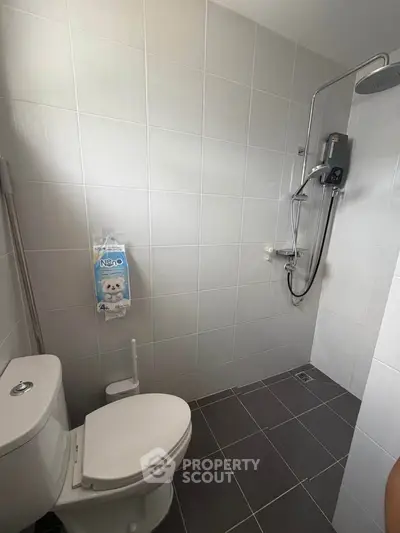 Modern bathroom with sleek shower and tiled walls in a contemporary home.