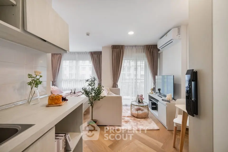 Modern living room with stylish decor and natural light, featuring a cozy seating area and elegant wooden flooring.