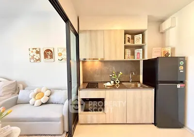 Modern compact kitchen with sleek appliances and cozy living area, perfect for urban living.
