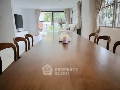 Spacious living room with elegant dining table and large windows for natural light.