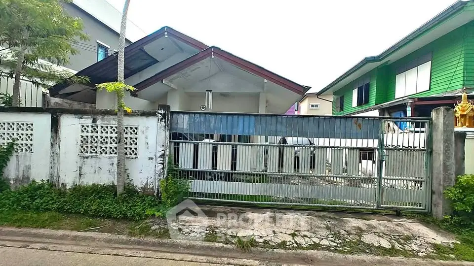 Charming residential home with gated entrance and lush greenery in a serene neighborhood.