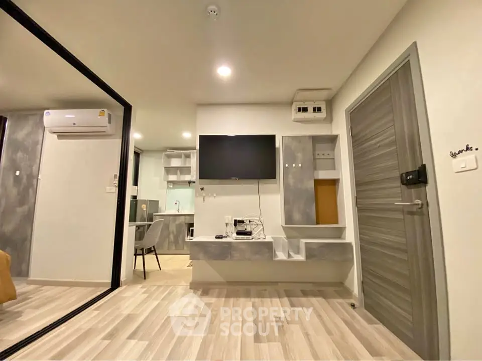 Modern living room with sleek design and wall-mounted TV in a stylish apartment.