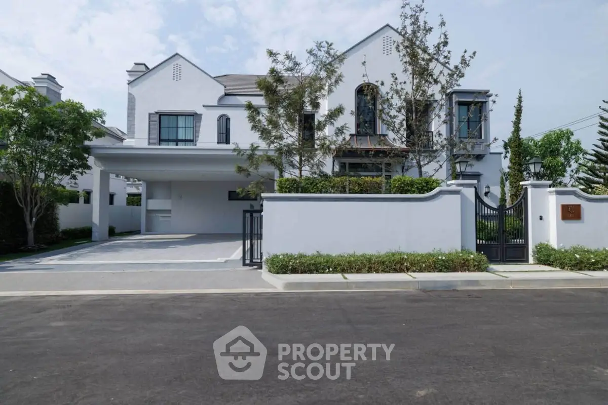 Elegant modern house with spacious driveway and lush greenery, perfect for luxurious living.