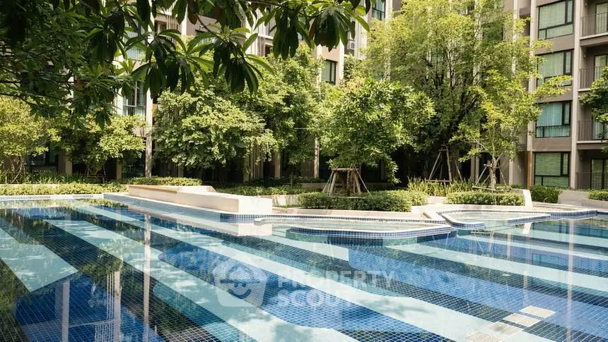 Luxurious apartment complex with a stunning outdoor pool and lush greenery.