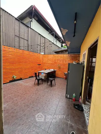 Charming outdoor patio with wooden privacy fence and cozy seating area.