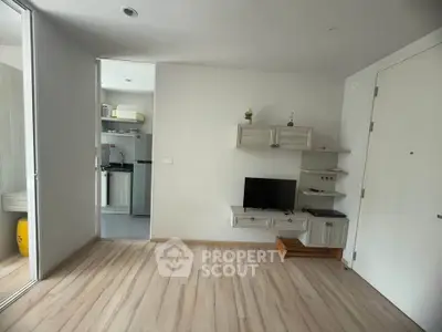 Modern living room with wooden flooring and compact kitchen view