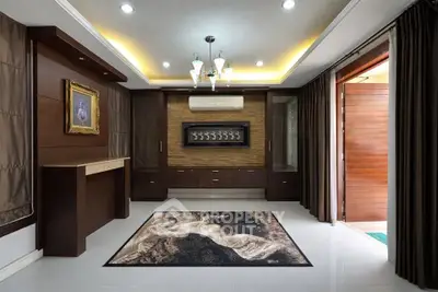Elegant living room with modern decor and stylish lighting, featuring a unique wall art and luxurious rug.