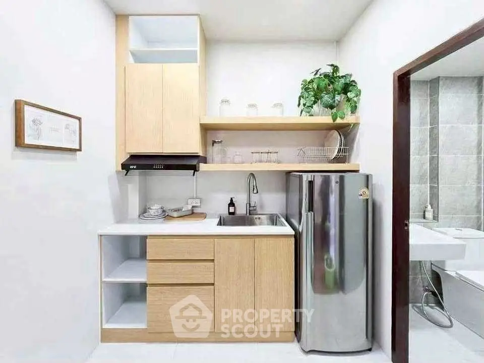 Modern compact kitchen with sleek design and stainless steel appliances.