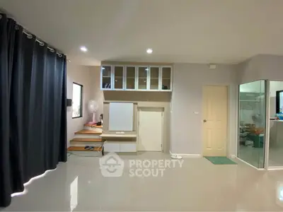 Spacious modern living room with sleek flooring and built-in storage solutions.