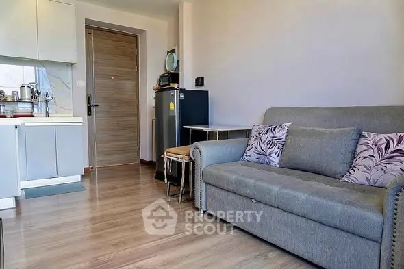 Modern living room with cozy sofa and compact kitchen area, perfect for urban living.