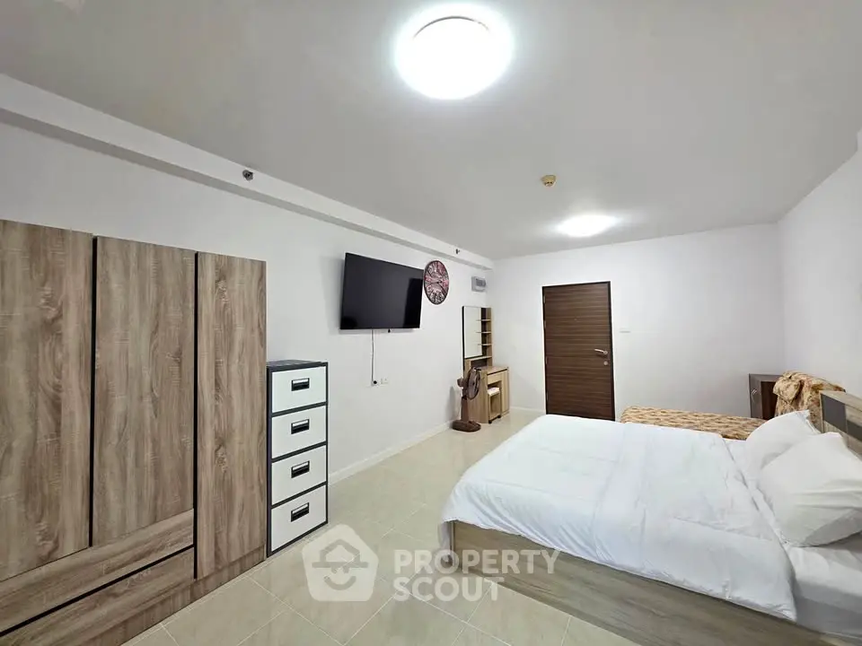 Spacious bedroom with modern furnishings and ample storage in a stylish apartment.