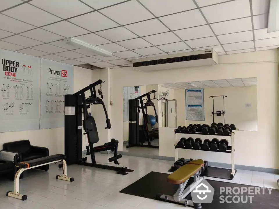 Modern gym with exercise equipment and mirrors in a real estate property