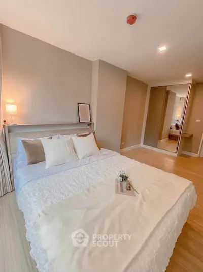 Spacious modern bedroom with cozy decor and mirrored wardrobe