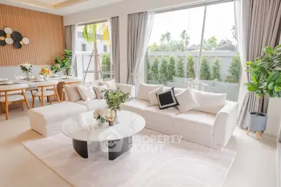Luxurious living room with elegant decor and large windows offering garden views.