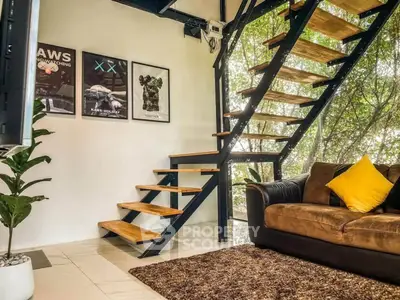 Stylish modern living room with open staircase and cozy seating area.