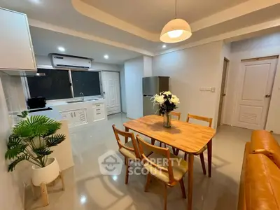 Modern open-layout kitchen and dining area with stylish furniture and bright lighting.
