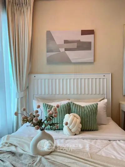 Cozy bedroom with stylish decor and natural light, featuring elegant bedding and modern artwork.