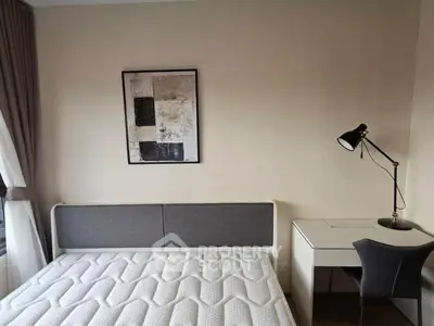 Modern bedroom with stylish decor, featuring a comfortable bed and sleek desk setup.