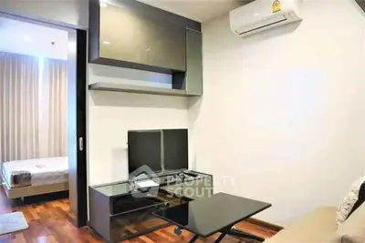 Modern living room with sleek furniture and air conditioning, adjacent to a cozy bedroom.