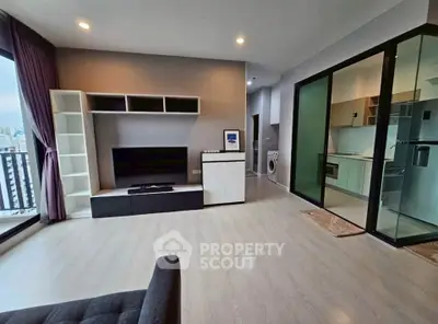 Modern living room with open kitchen and city view, featuring sleek design and ample natural light.