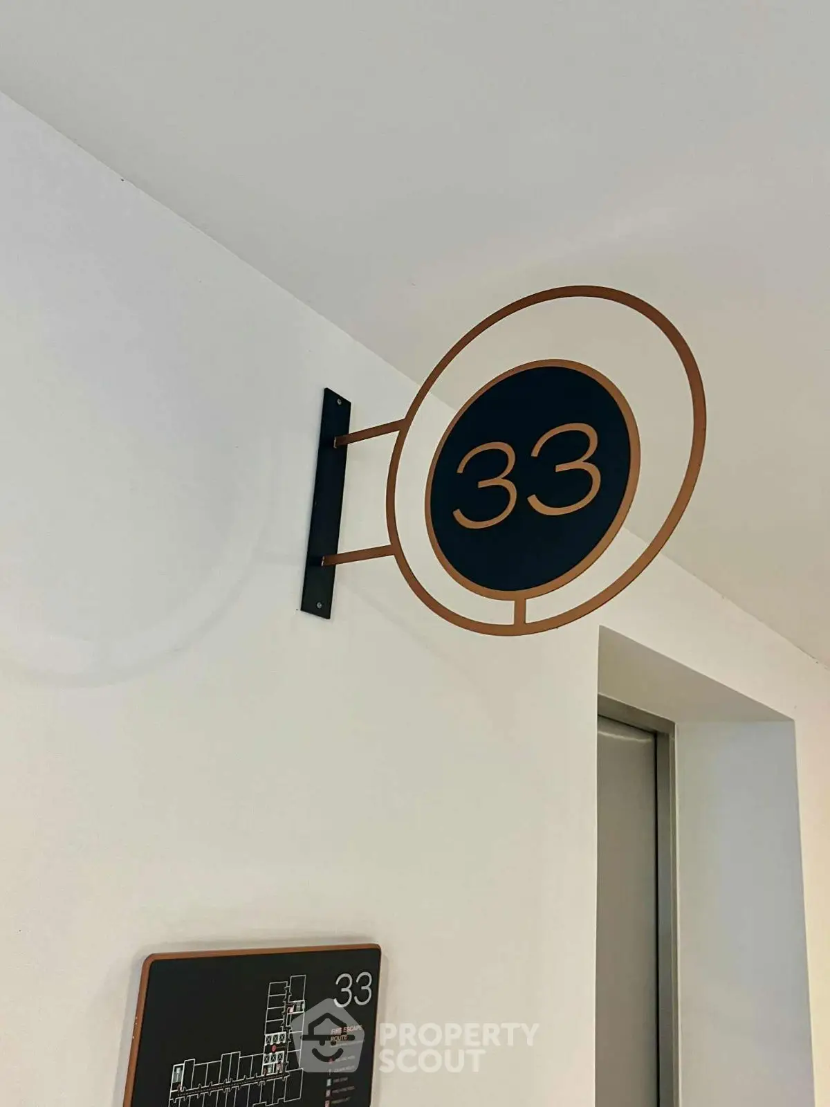 Modern apartment floor number sign with sleek design near elevator entrance.