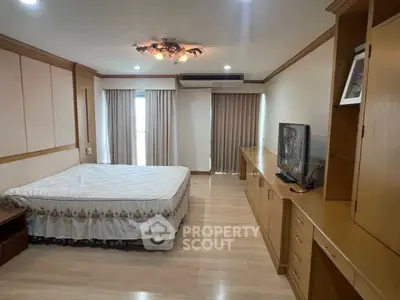 Spacious bedroom with elegant wooden furnishings and natural light