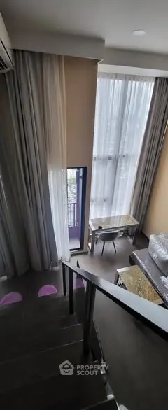 Modern duplex living room with high ceilings and large windows