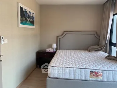 Modern bedroom with elegant headboard and large window for natural light.