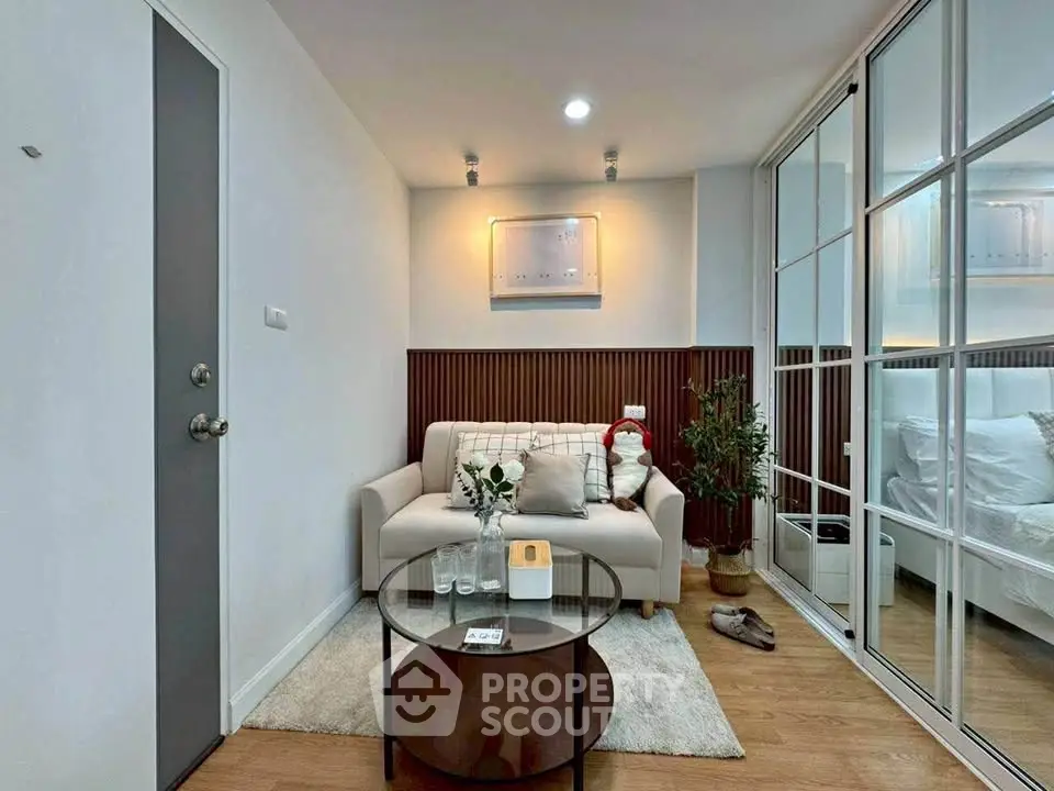Cozy living room with modern decor and glass partition in stylish apartment.