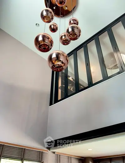 Modern interior with elegant pendant lighting and large windows in a stylish living space.