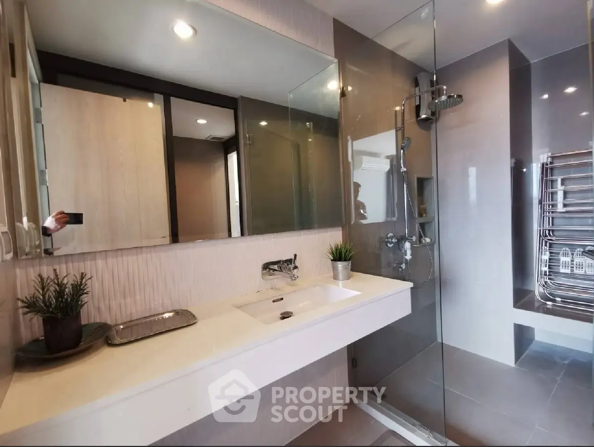 Modern bathroom with glass shower and sleek fixtures in a contemporary home.